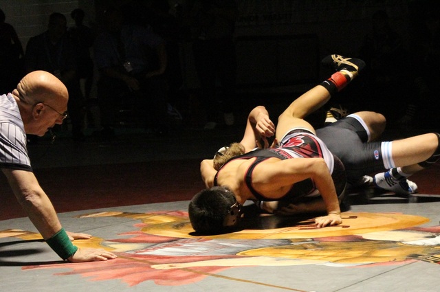 Cimarron-Memorial’s Daniel Rodriguez puts the finishing touches on his pinfall victory ...