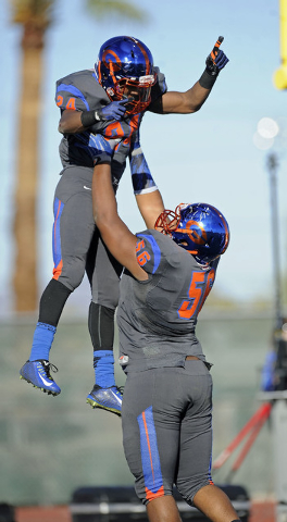 Bishop Gorman offensive guard Jackson Perry (56) hoists running back Russell Booze (24) afte ...