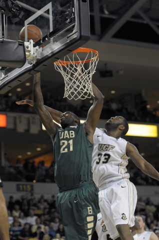 UAB center Beas Hamga, left, puts up a shot in front of Central Florida’s Keith Clanto ...