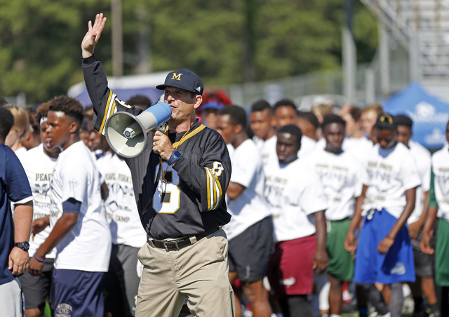 Michigan football coach Jim Harbaugh urges the more than 500 high school football players to ...