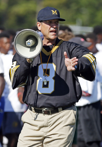Michigan football coach Jim Harbaugh encourages the more than 500 high school football playe ...