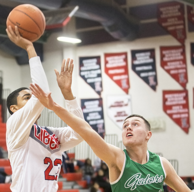 Green Valley’s Cameron Bower (1) reaches to block the shot of Liberty’s Julian S ...