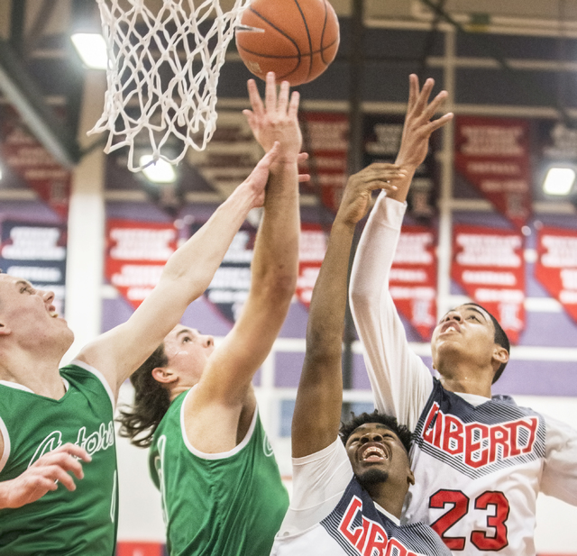 Liberty’s Julian Strawther (23) and Daryl Finley (5) fight for a loose ball with Green ...