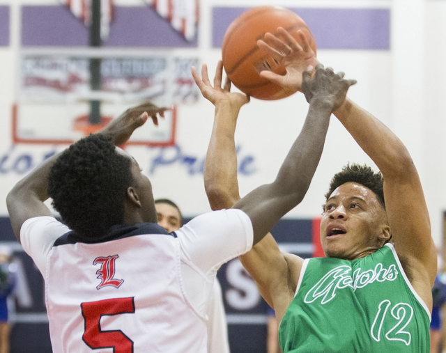 Green Valley’s Eric Johnson (12) gets fouled by Liberty’s Daryl Finley (5) duri ...