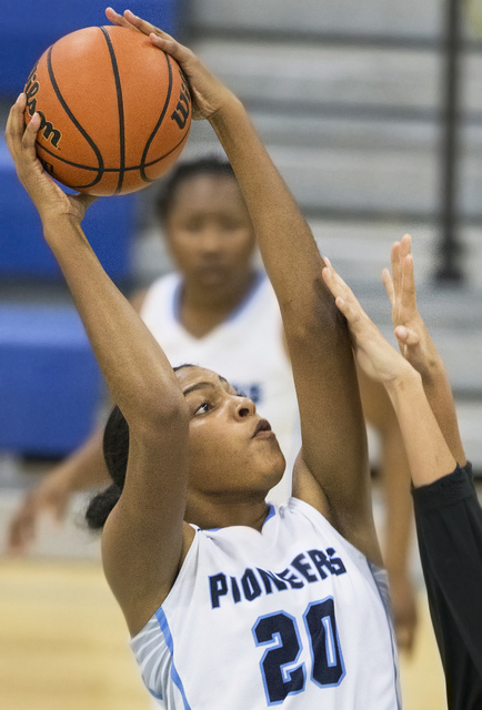 Canyon Springs’ Yemiyah Morris (20) shoots a jump shot with a hand in her face during ...