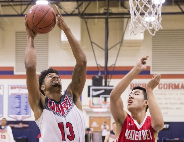 Liberty’s Dyllan Robinson (13) shoots over Mater Dei’s Michael Wang (23) during ...