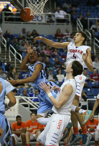 Canyon Springs’ Darrell McCall shoots around Bishop Gorman defenders Chase Jeter (4) a ...