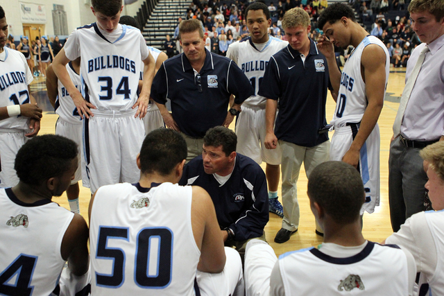 Centennial coach Todd Allen talks to his players in the fourth quarter of a basketball game ...