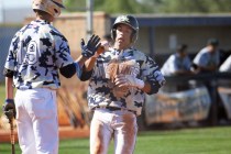Shadow Ridge’s Eric Jordan, right, crosses home plate by Trevin Reynolds to score the ...