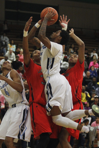Canyon Springs’ Shaquile Carr (23) shoots over Las Vegas’ Tyler Bey (30) and Re& ...