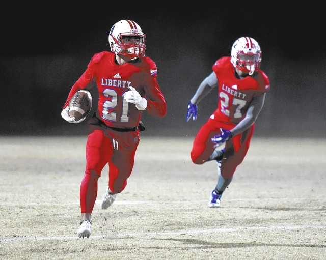 Liberty’s Darion Acohido (21) runs against Basic during the second half of a high scho ...