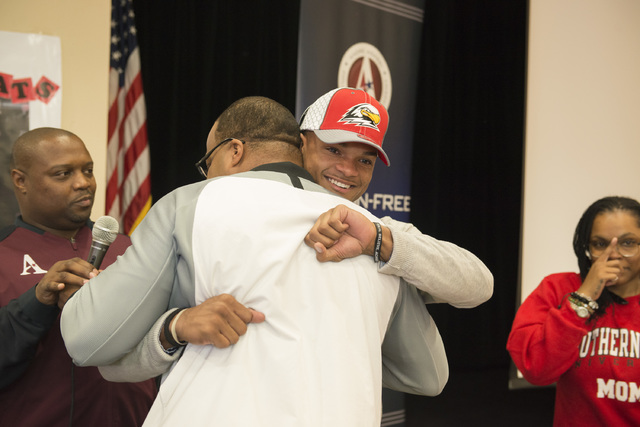 Agassi Prep’s Zeivaun Ned receives a hug after signing to play football at Southern Ut ...