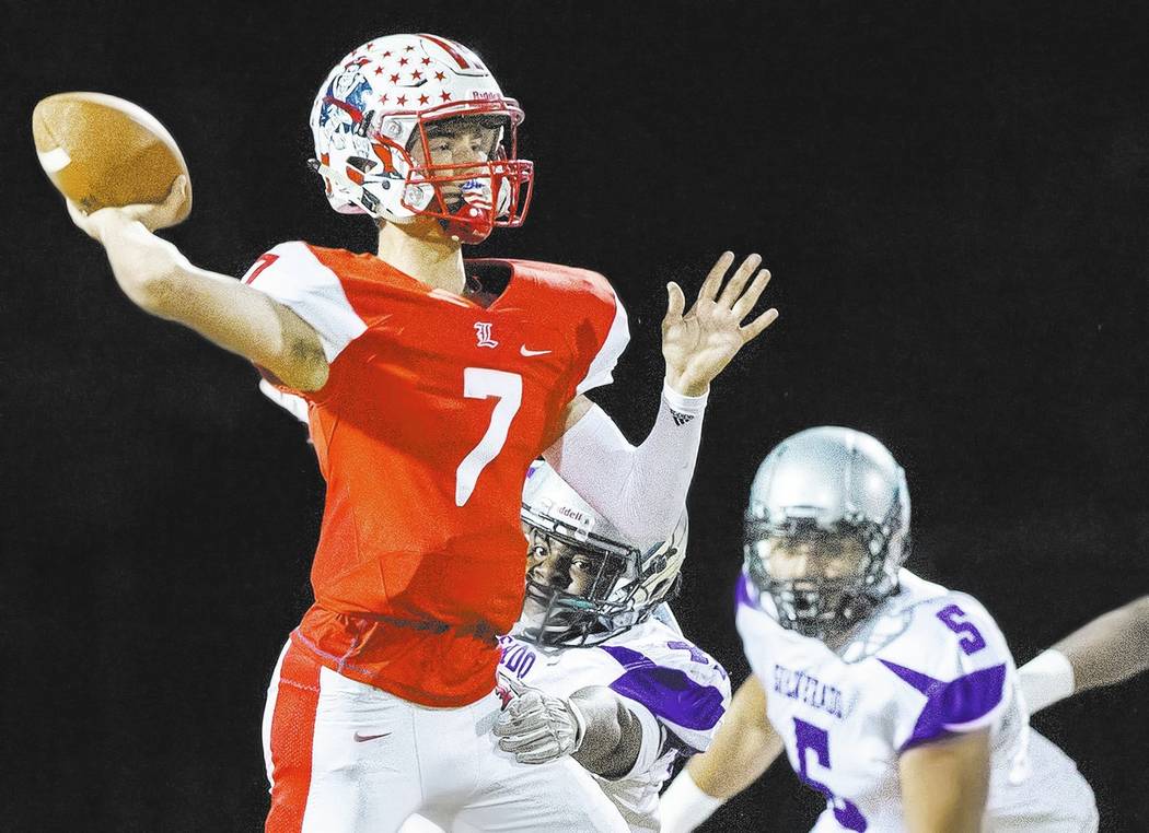 Liberty’s Kenyon Oblad (7) makes a pass with Silverado defenders on his back during th ...