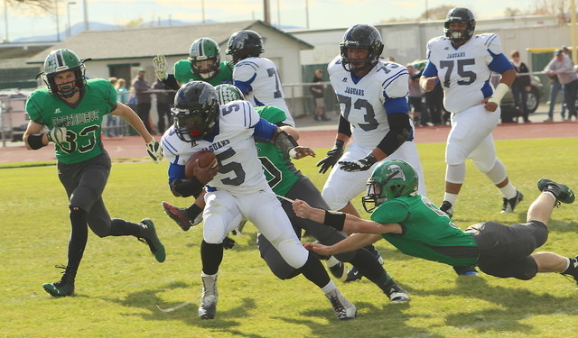 Trae Workman (9) of Churchill County pulls on Dillard Davis’ belt to drag him down deep in ...