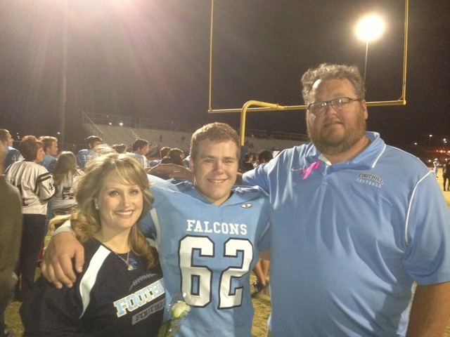 JD Reynolds, center, is shown with his parents Kelli and Jerry during a high school football ...