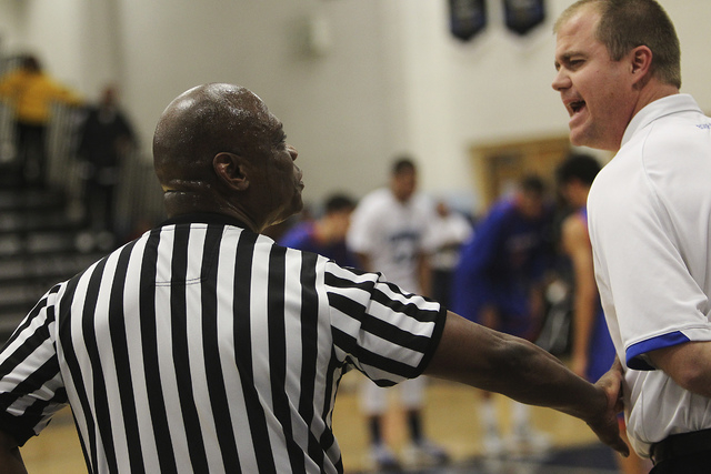 Referee Sam Gibson keeps his distance from Bishop Gorman head coach Grant Rice during high s ...