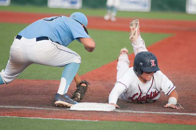 Liberty’s Josh McCollum dives back to first base while Centennial’s Travis Steve ...