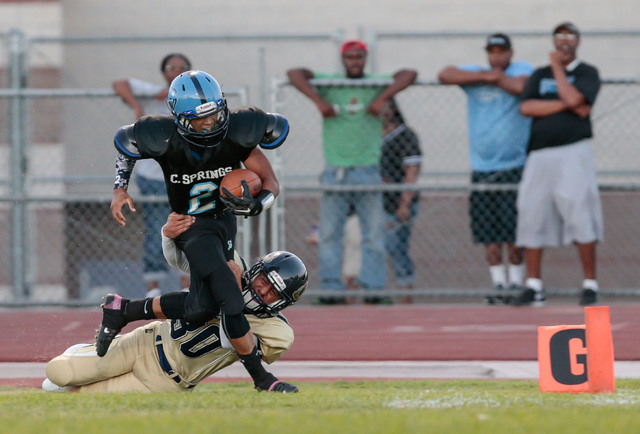 Canyon Springs junior Diamante Burton (2) attempts to break a tackle by Cheyenne senior Jose ...