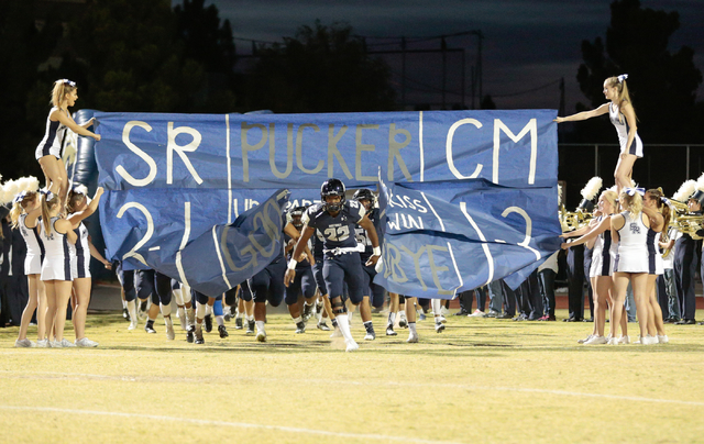Shadow Ridge junior Aubrey Nellems (22) busts through the cheer leaders paper banner prior t ...