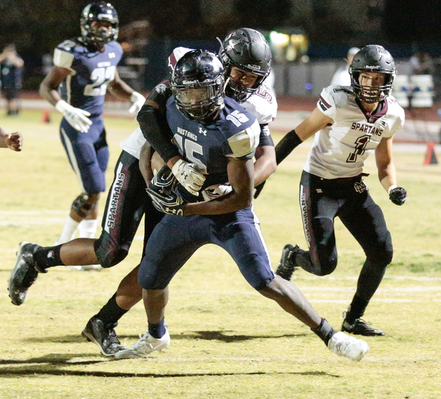 Shadow Ridge senior Malik Lindsey (15) moves the ball while Cimarron-Memorial junior Jonah L ...