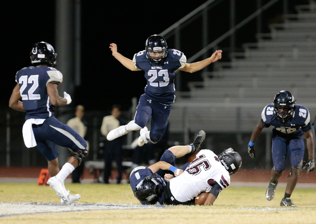 Shadow Ridge junior Sergio Martinez (23) leaps up to avoid players below him during a footba ...