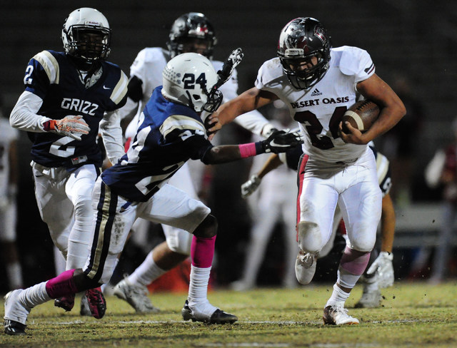 Desert running back Yeyro Guzman, right, fends off Spring Valley safety Marquon Bell in the ...