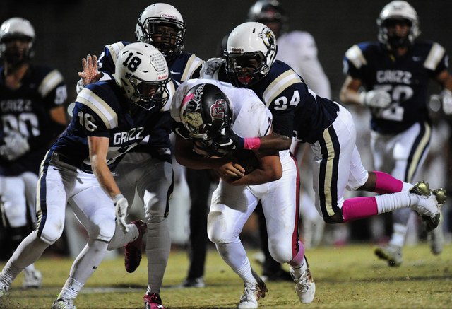 Desert running back Yeyro Guzman, centyer, is tackled by Spring Valley safety Marquon Bell ( ...