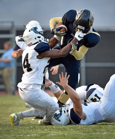 Cheyenne’s Corwin Bush is brought down by Foothill’s Marchaun Norris (24) and Ju ...