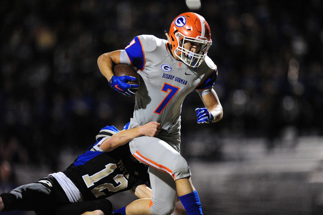 Bishop Gorman running back Biaggio Ali Walsh scores a touchdown despite being wrapped up by ...