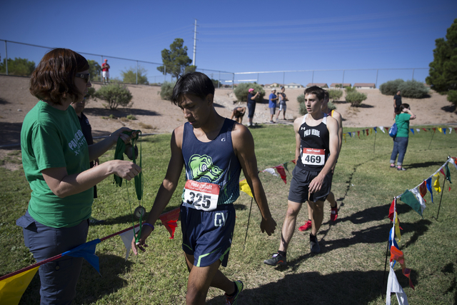 Green Valley’s Omar Rubio receives a medal after finishing in second place in the cros ...
