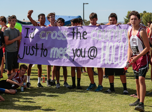 Members of the Desert Oasis High School boys cross country team hold a sign as they wait for ...
