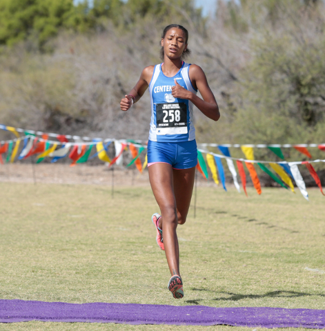 Centennial High School cross country runner Alexis Gourrier (258) runs across finish line to ...