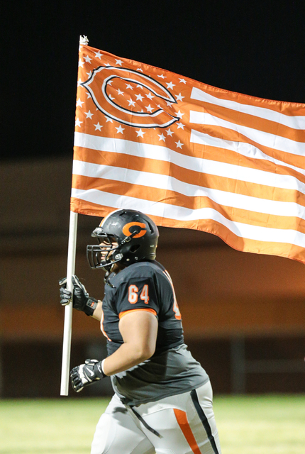 Chaparral senior Kalani Axtell-Lealao (64) runs down the field with the Cowboy’s flag ...