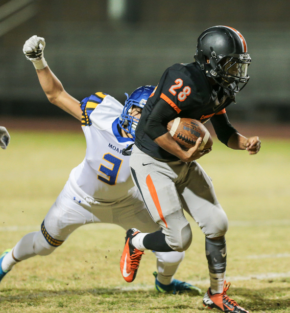 Moapa Valley sophomore Leo Rios (3) swings his arm in an attempt to grab Chaparral junior D ...