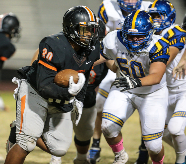 Chaparral senior Jacob Ford (30) works his way around Moapa Valley junior Gavin Henrie (50) ...