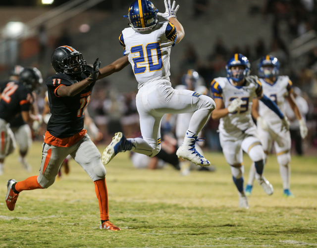 Moapa Valley senior Konner Andrew (20), right, jumps up for an interception in front of Chap ...