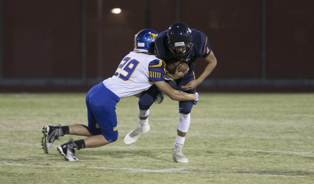 Legacy High quarterback Roberto Valenzuela, right, is brought down by Moapa Valley’s T ...