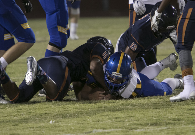 Legacy High, left, and Moapa Valley players vie for a ball during a varsity football game at ...