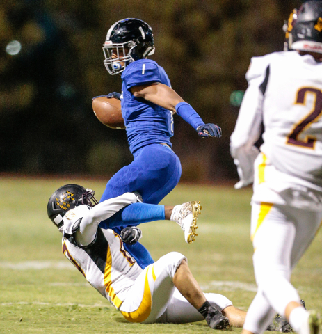 Pahrump Valley senior Jesse Dillon (17) attempts to bring down ball carrier Desert Pines sen ...