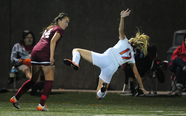 Bishop Gorman forward Colbi Rohr (17) is tripped up by Desert Oasis forward Miah Strellnauer ...