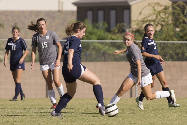 Centennial’s Shannon Hutchins (13) fights for the ball with Arbor View’s Hannah ...
