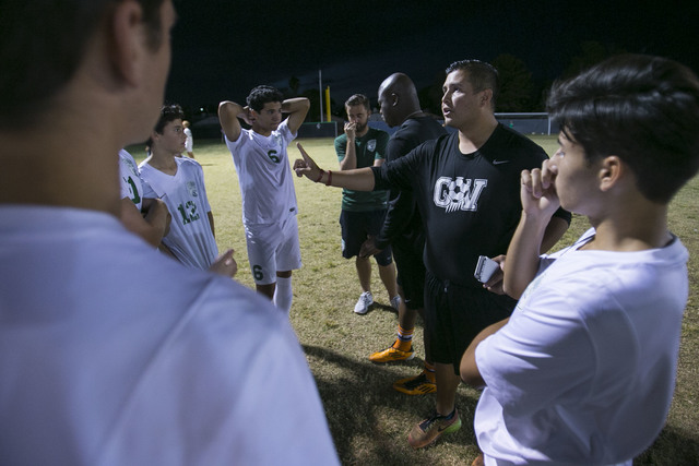 Green Valley soccer coach Jacob Rivera, second right, talks to his players at halftime durin ...