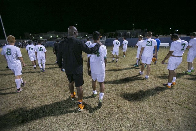 Green Valley assistant soccer coach Ben Adetoye consoles Thoren Kaufusi (4) after losing to ...
