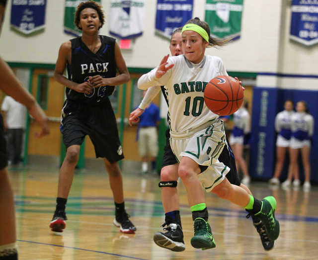 Green Valley’s Maggie Manwarren (10) drives past Basic’s Ashley Lampkey (24) on ...