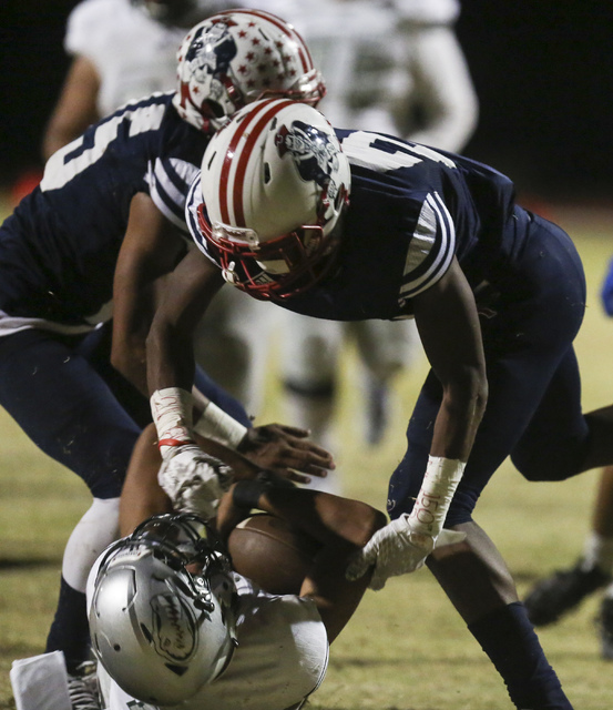 Green Valley quarterback Kalyja Waialae (18) is taken down by Liberty defense during a footb ...