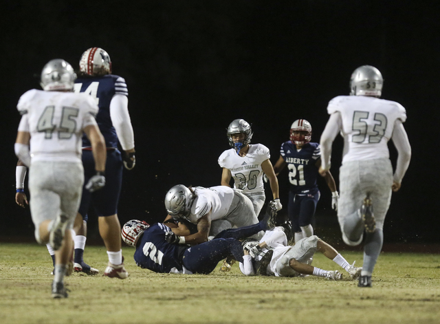 Liberty wide receiver Ethan Dedeaux (2) is taken down by Green Valley linebacker C.J. Araujo ...