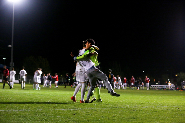 Coronado Cougars soccer team goalkeeper, Harrison Skinner, is hugged by teammates at the Bet ...