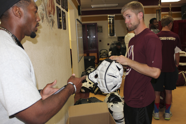 Faith Lutheran head coach Vernon Fox and assistant coach Grant Rolfsmeier chat while handing ...