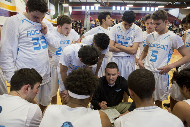 Adelson basketball team huddles for a timeout during the 2A boys state semifinal game at Del ...