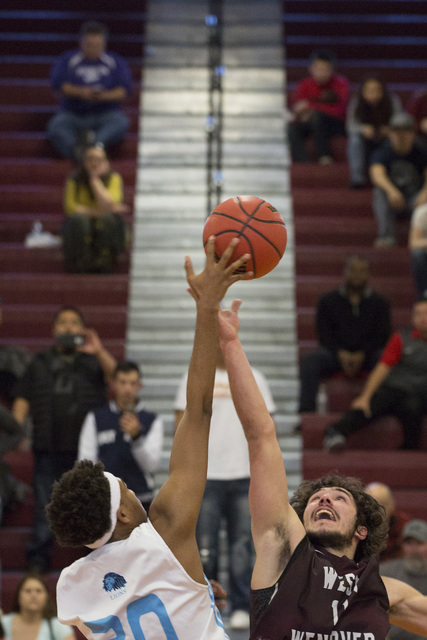 Adelson junior Miles Hagan, left, and West Wendover senior Zade Elton, right, fight for the ...